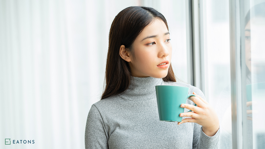Woman Drinking Coffee By A Sliding Window